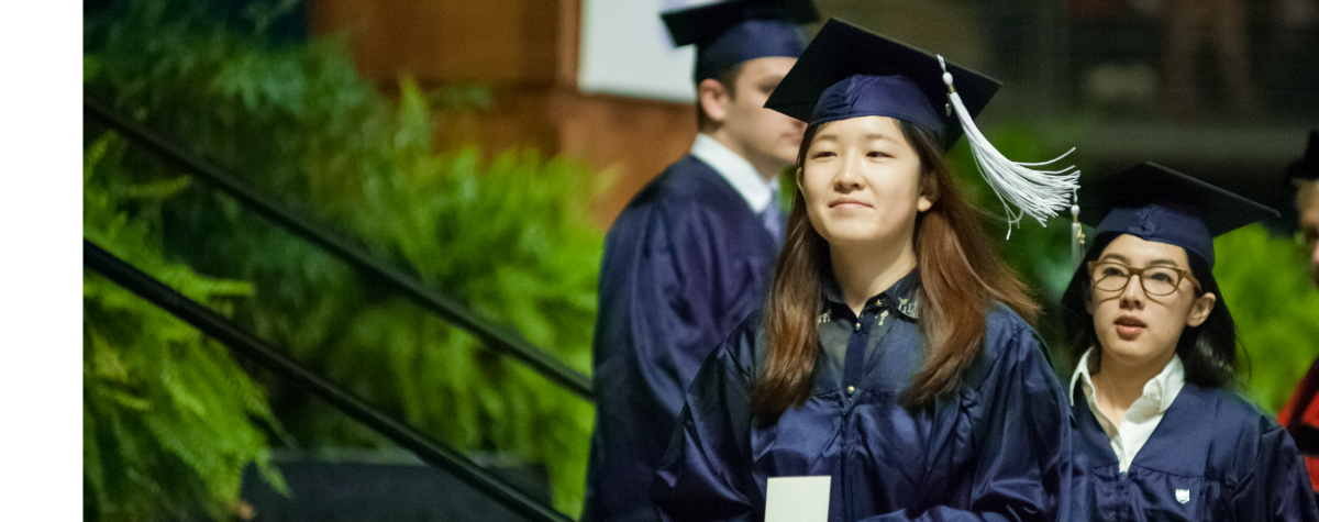students walking across the stage during graduation commencement cermony